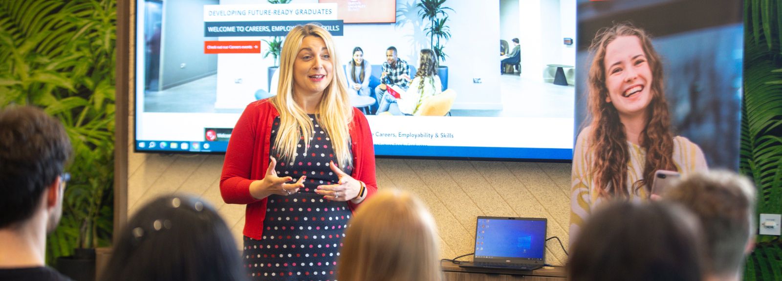 female standing in front of a room full of students